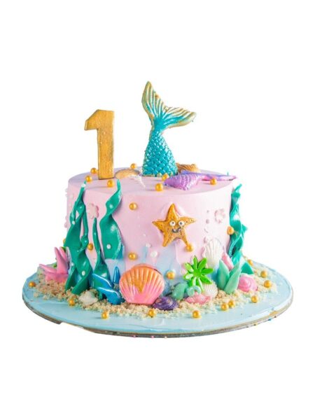 Underwater-themed cake with mermaid tail, seashells, starfish, and ocean décor.