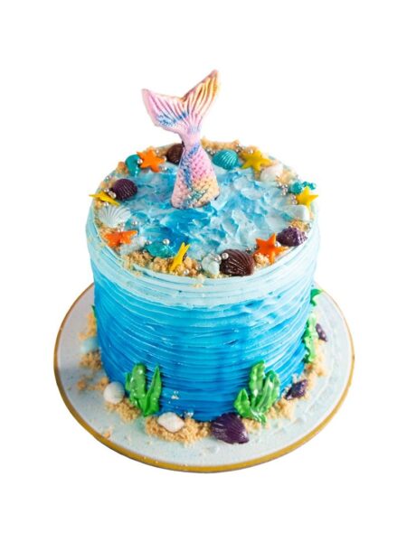 Underwater theme cake with mermaid tail, seashells, starfish, sea plants, and ocean wave design.