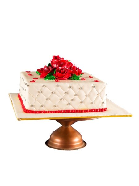 Elegant floral cake with quilted design, pearl accents, and red roses on top.