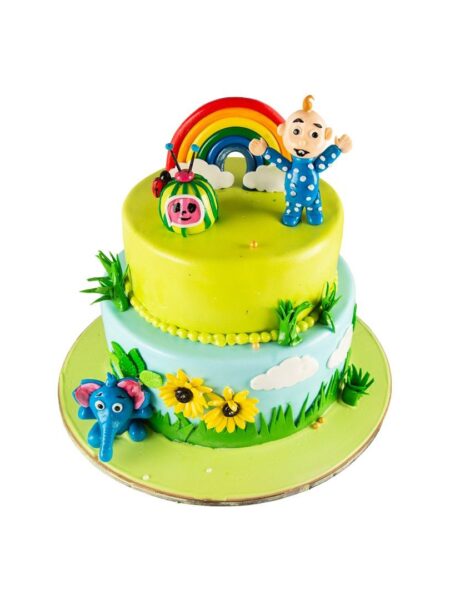 Cocomelon theme cake with rainbow, baby figure, flowers, and elephant décor.